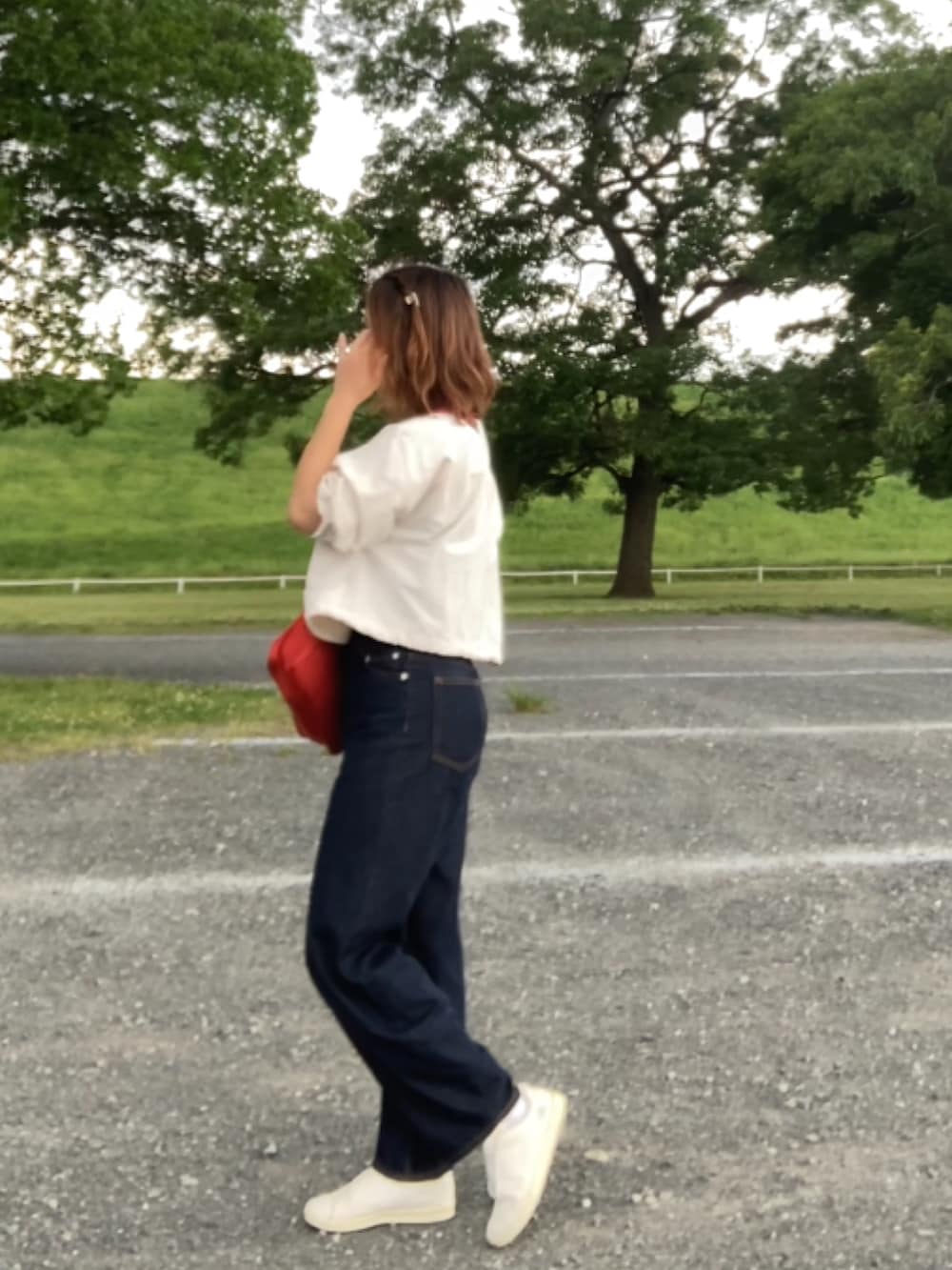 ブルー系のデニムパンツ、グレー系のTシャツ/カットソー、ホワイト系のスリッポンを着用したレディースの夏コーディネートの3枚目の写真