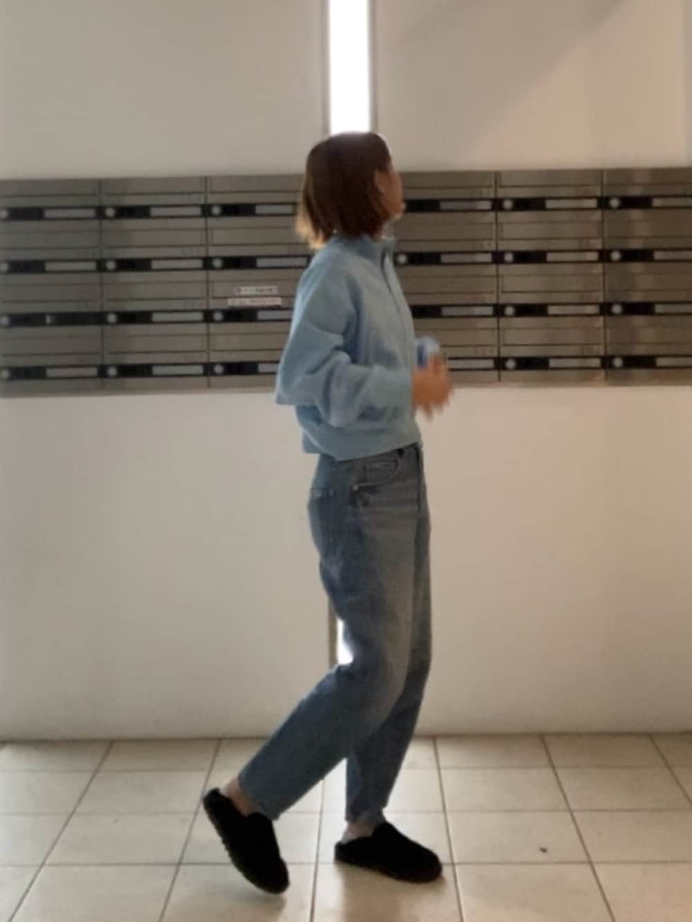 ブルー系のデニムパンツ、ブラック系のスリッポンを着用したレディースの秋コーディネートの2枚目の写真