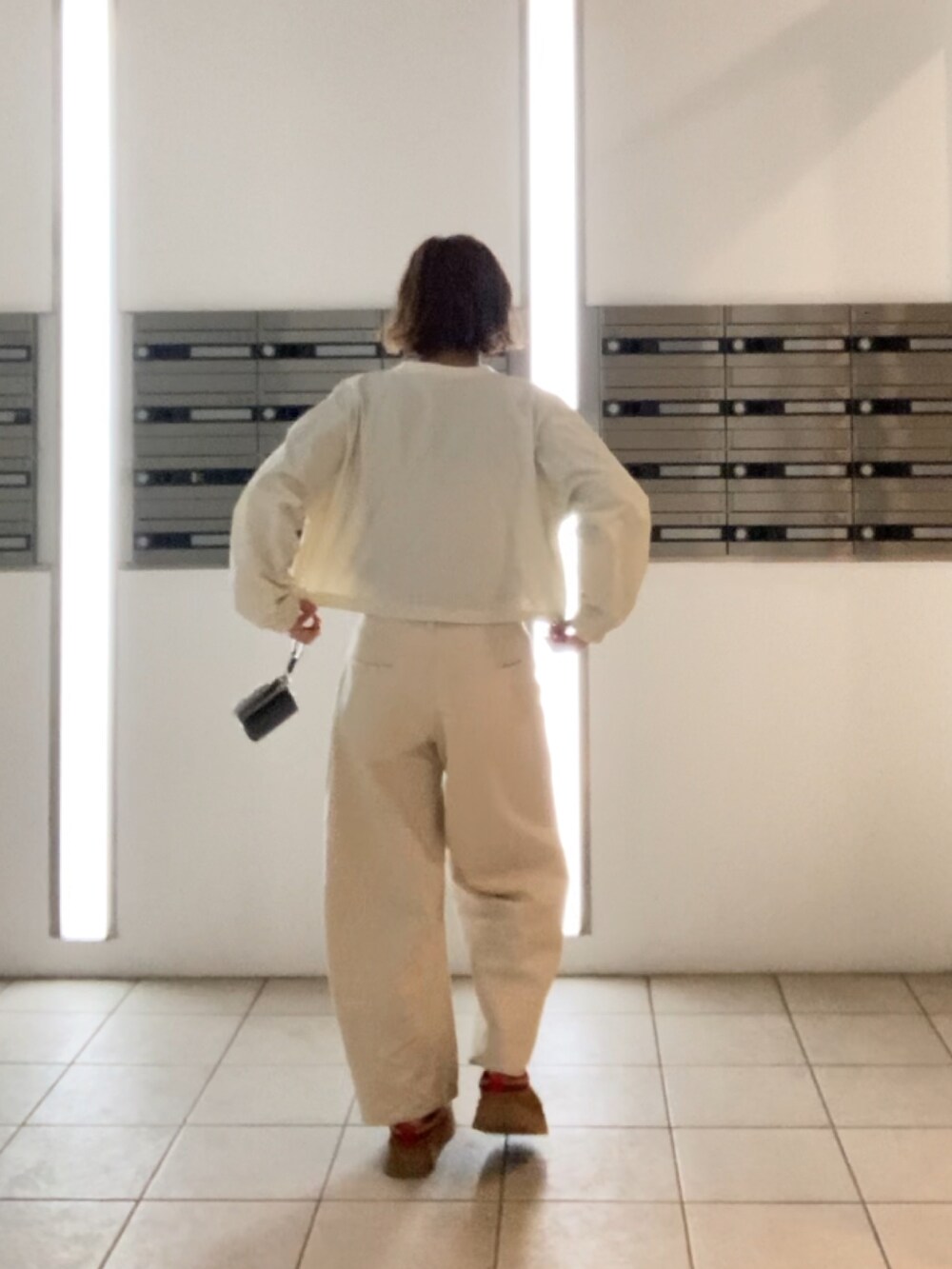 ホワイト系のTシャツ/カットソー、ブラウン系のブーツ、ホワイト系のデニムパンツを着用したレディースの冬コーディネートの3枚目の写真