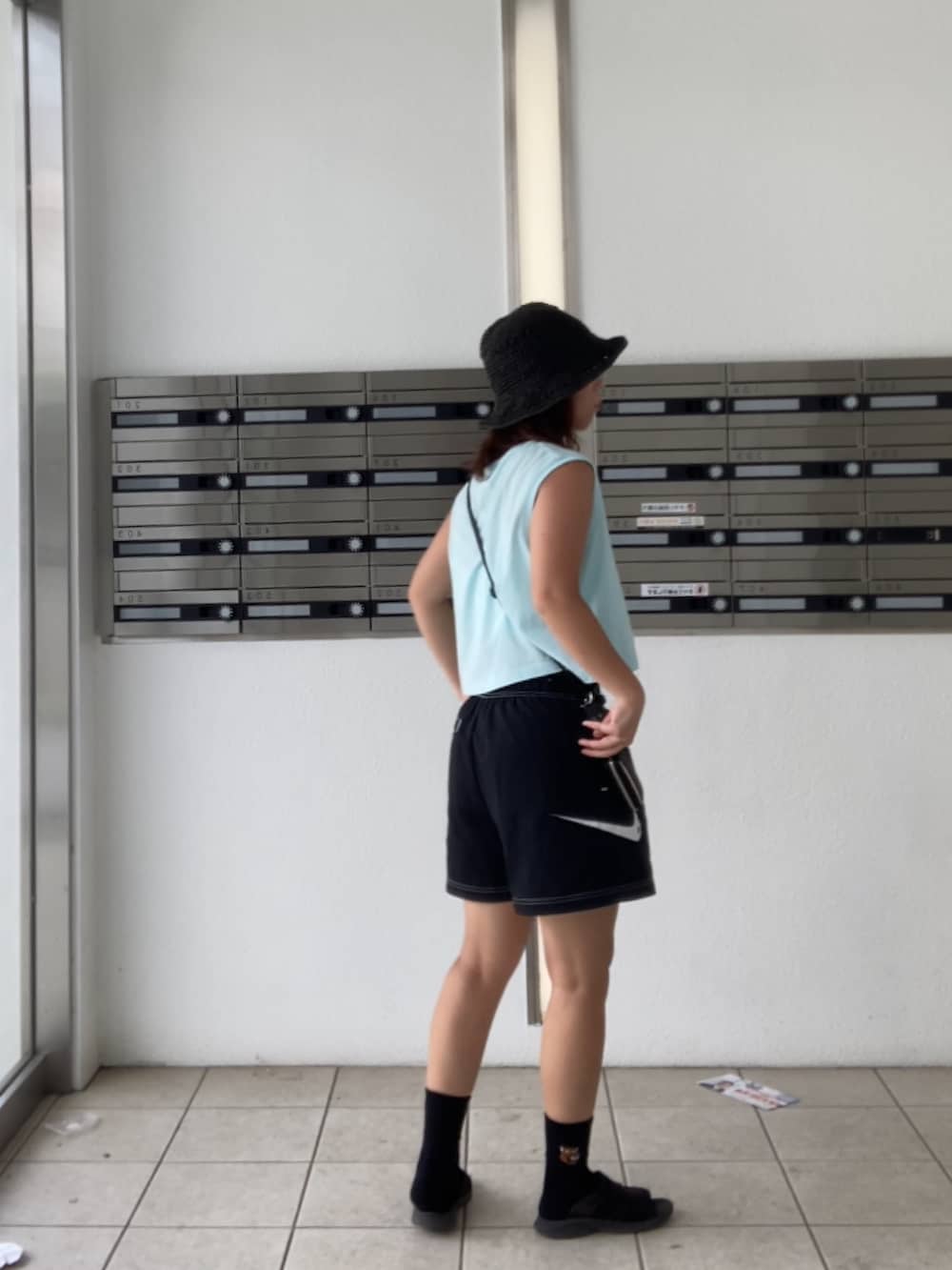 ブラック系のサンダル、ブルー系のTシャツ/カットソー、ブラック系のソックス/靴下を着用したレディースの夏コーディネートの2枚目の写真