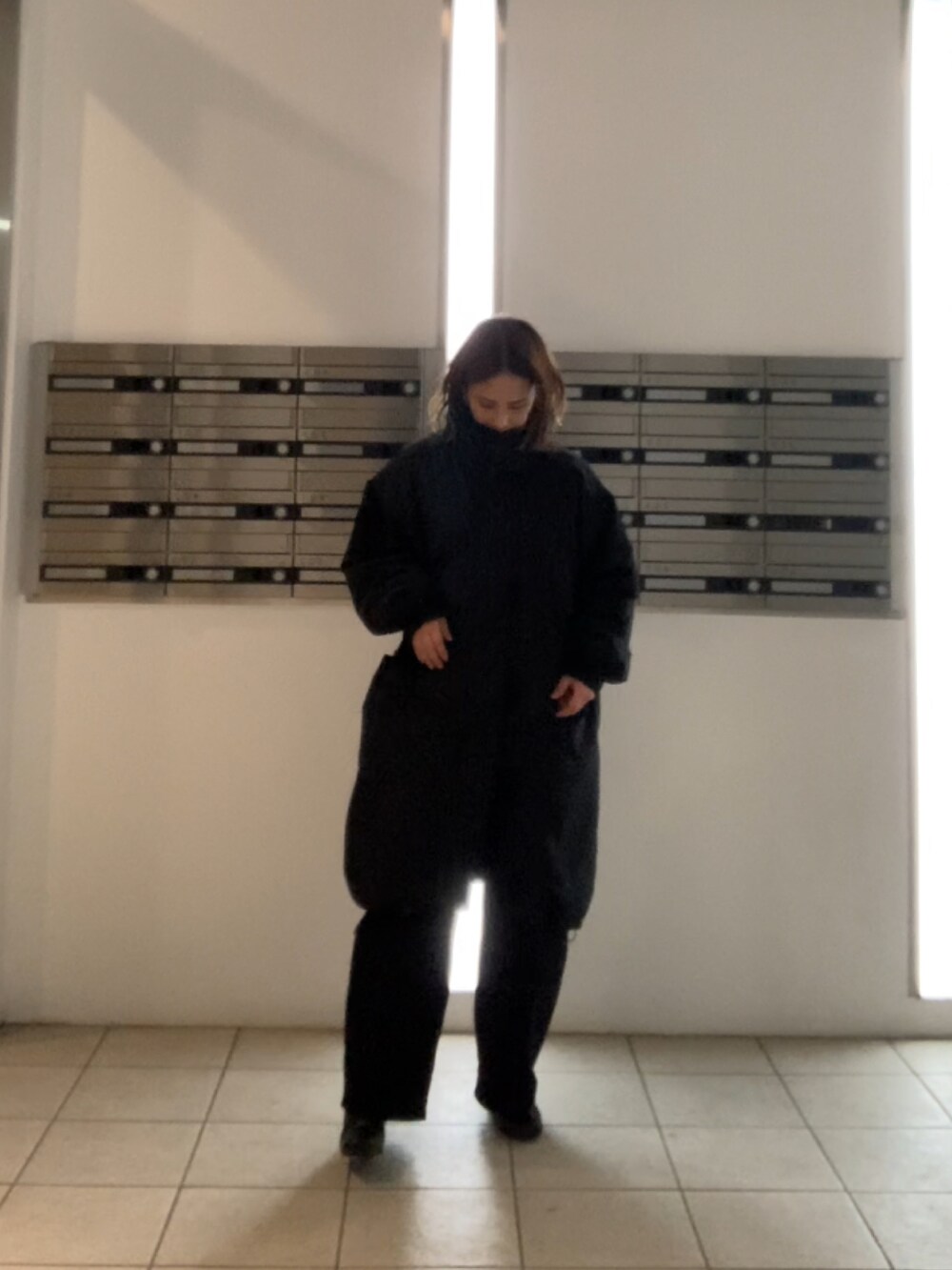 ブラック系のダウンジャケット/コート、ブラック系のブーツ、ホワイト系のデニムパンツを着用したレディースの冬コーディネートの3枚目の写真