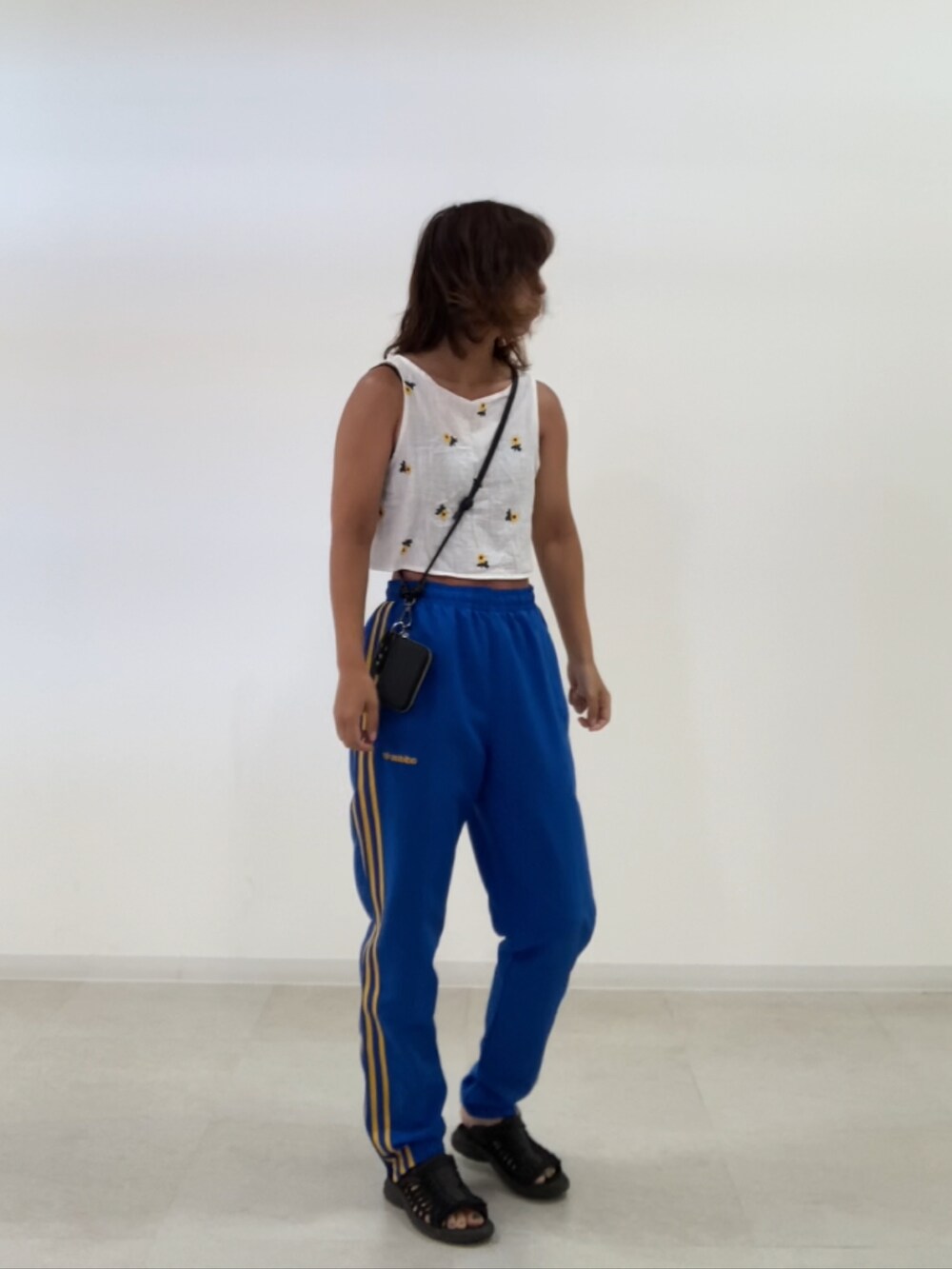 ブラック系のサンダル、ブルー系のパンツ、ブラック系のスマホグッズを着用したレディースの夏コーディネートの2枚目の写真