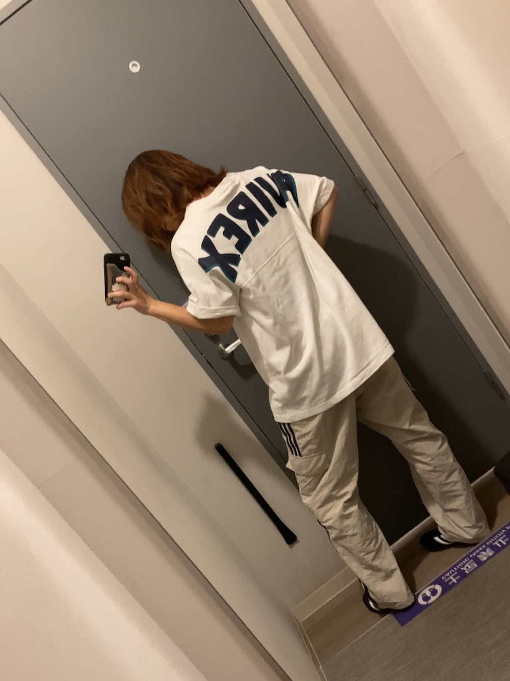 ベージュ系のカーゴパンツ、ブラック系のスニーカー、ホワイト系のTシャツ/カットソーを着用したレディースの夏コーディネートの2枚目の写真