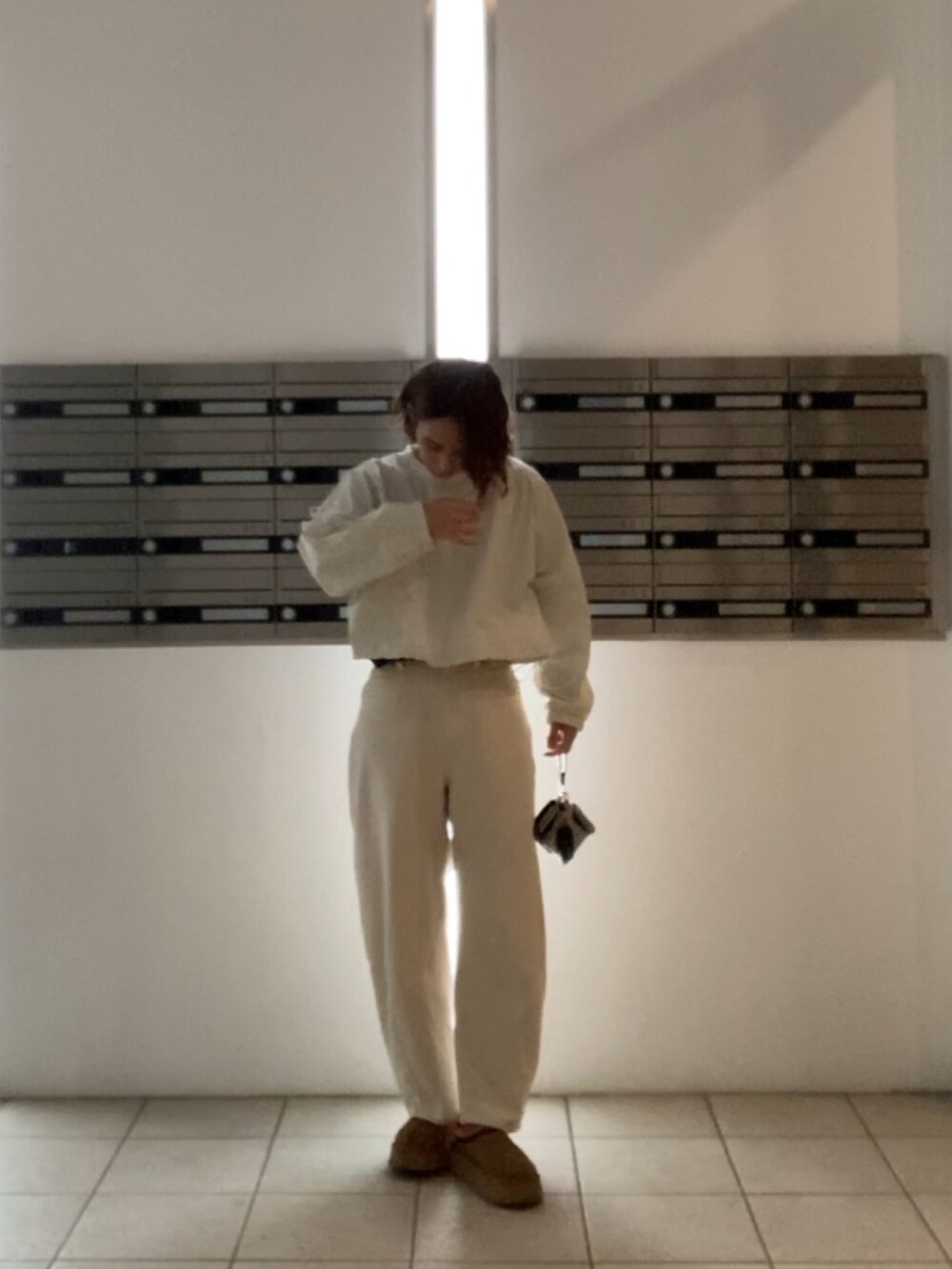 ホワイト系のTシャツ/カットソー、ブラウン系のブーツ、ホワイト系のデニムパンツを着用したレディースの冬コーディネートの2枚目の写真