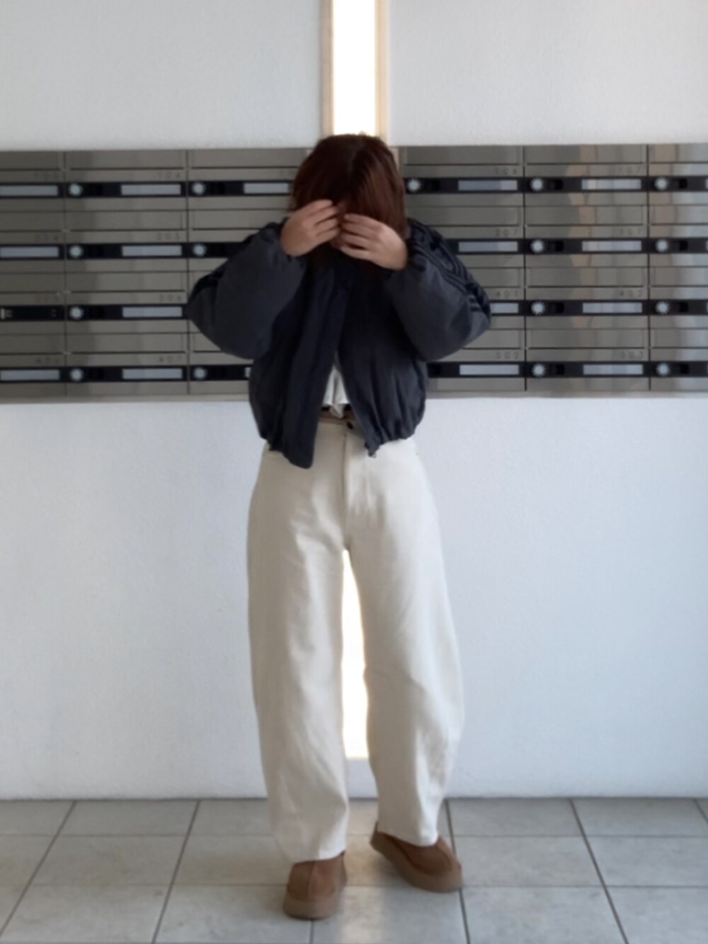 ブラウン系のブーツ、ホワイト系のTシャツ/カットソー、ホワイト系のデニムパンツを着用したレディースの冬コーディネートの3枚目の写真