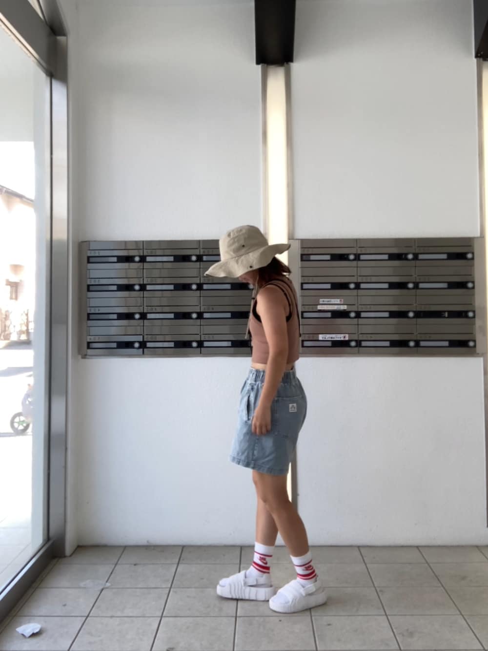 ブルー系のその他パンツ、ホワイト系のサンダル、レッド系のソックス/靴下を着用したレディースの夏コーディネートの2枚目の写真