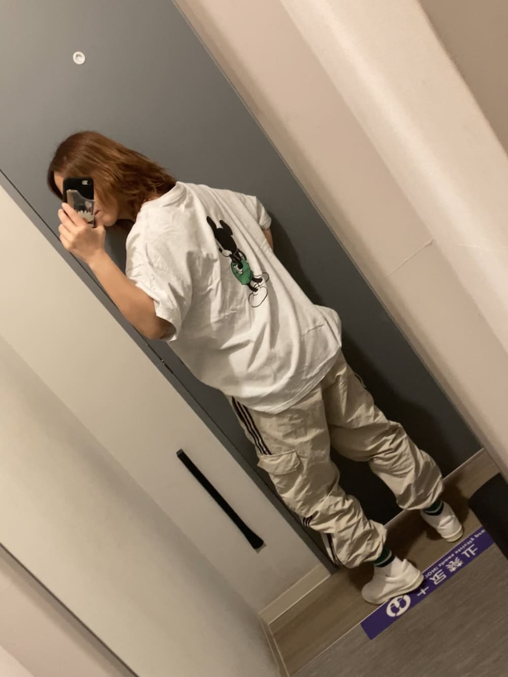 ベージュ系のカーゴパンツ、ホワイト系のスリッポン、ベージュ系のTシャツ/カットソーを着用したレディースの春コーディネートの2枚目の写真