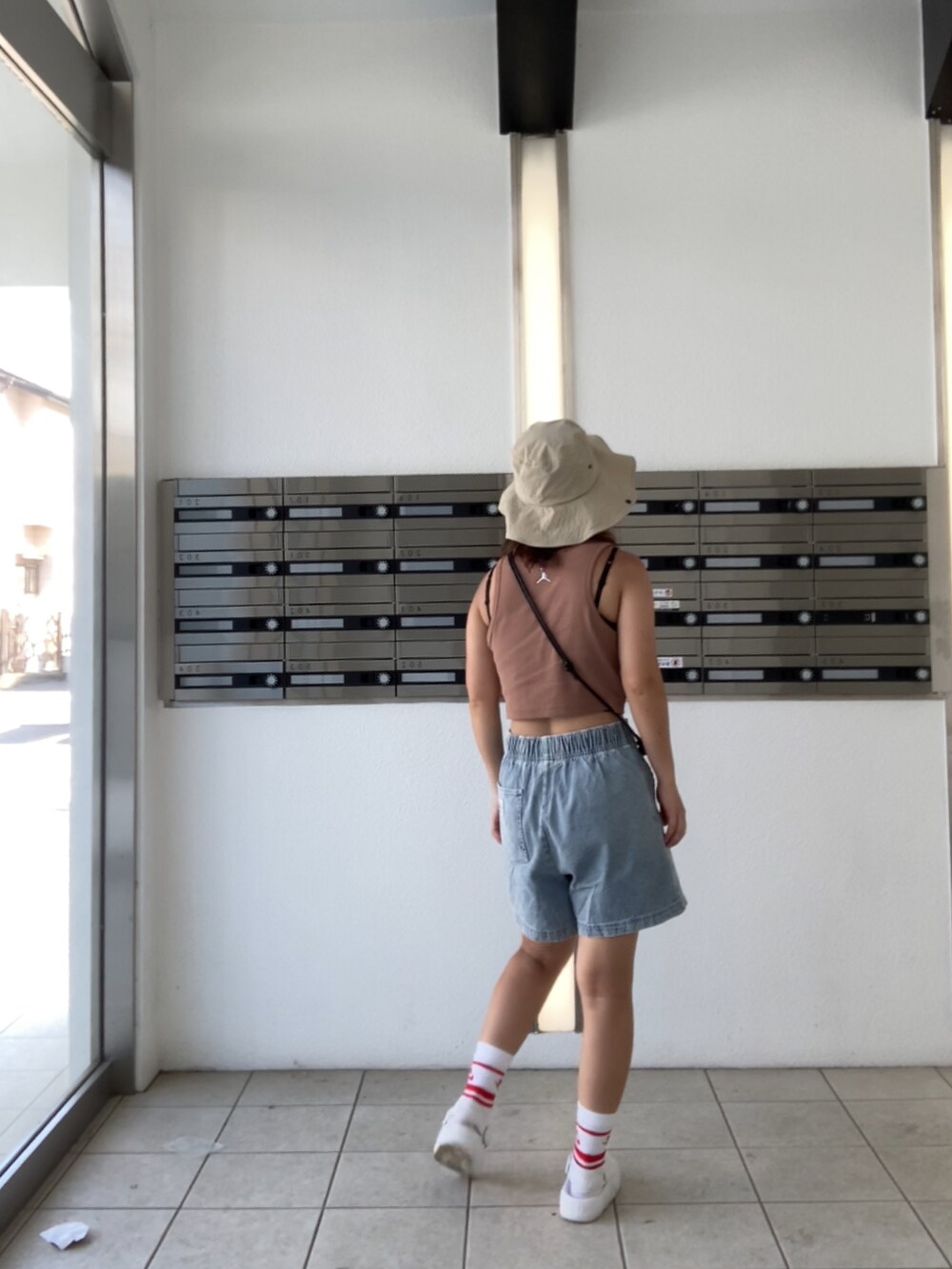 ブルー系のその他パンツ、ホワイト系のサンダル、レッド系のソックス/靴下を着用したレディースの夏コーディネートの3枚目の写真