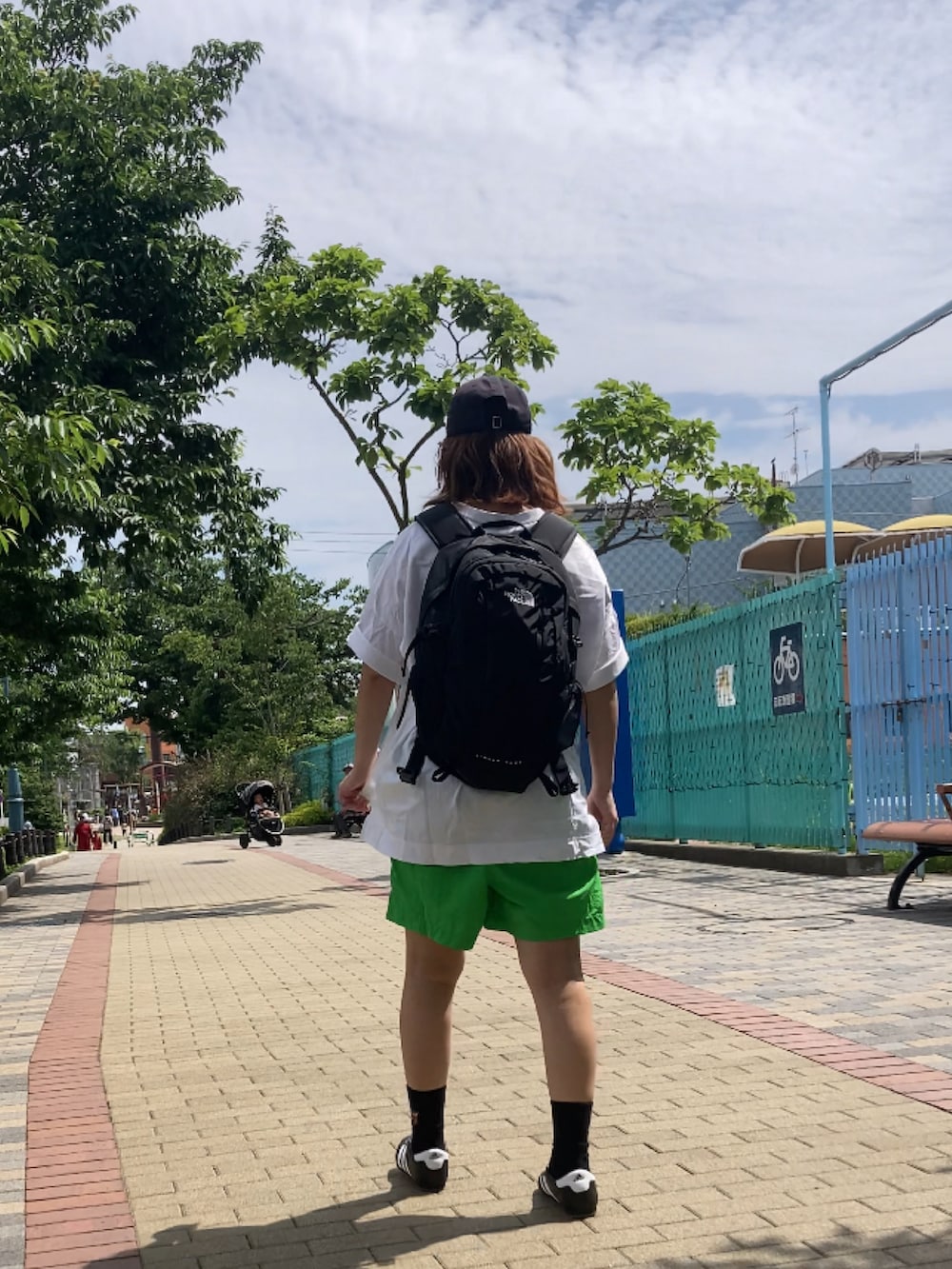 ブラック系のスニーカー、ブラック系のバックパック/リュック、グリーン系のその他パンツを着用したレディースの夏コーディネートの2枚目の写真