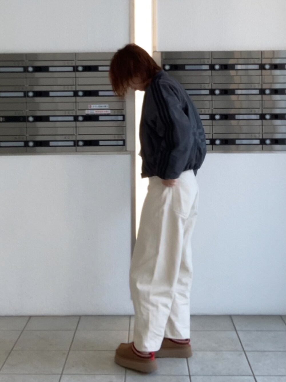 ブラウン系のブーツ、ホワイト系のTシャツ/カットソー、ホワイト系のデニムパンツを着用したレディースの冬コーディネートの2枚目の写真