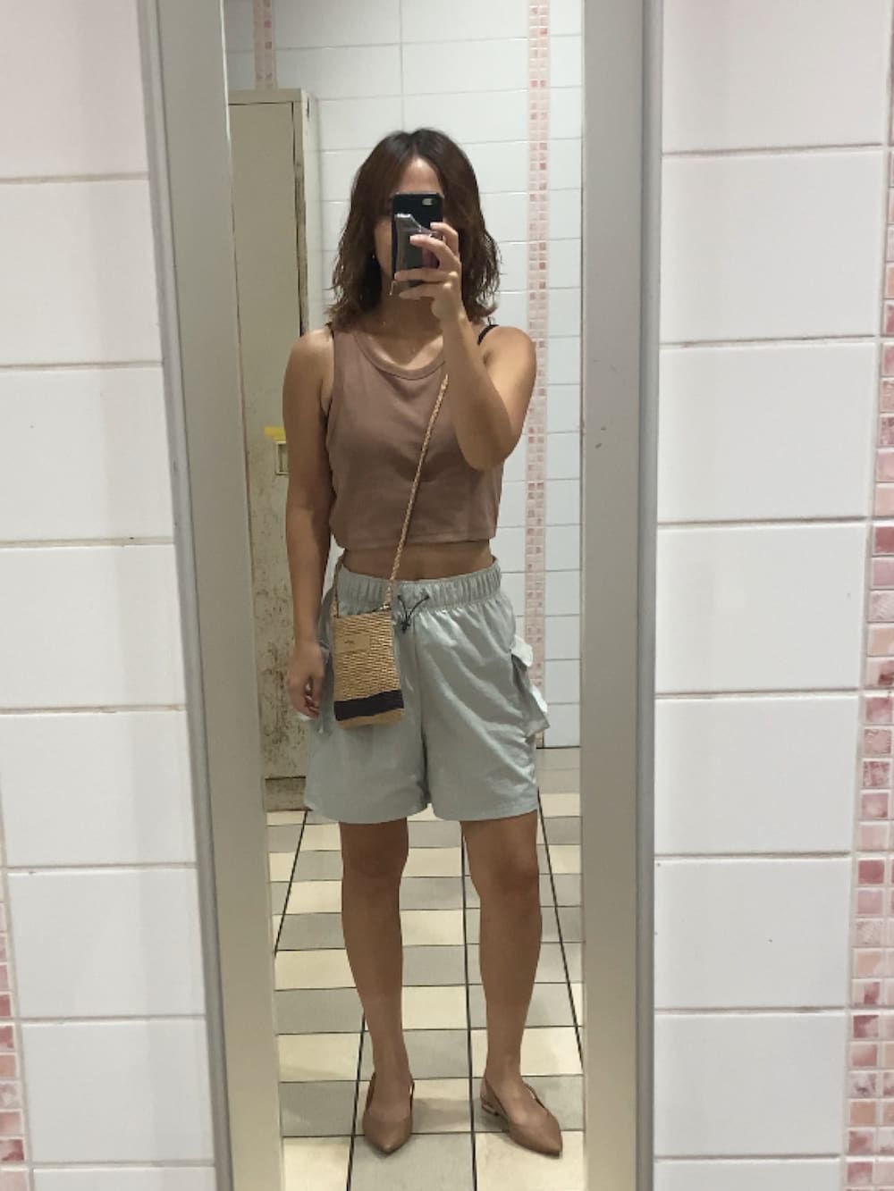 グレー系のカーゴパンツを着用したレディースの夏コーディネートの2枚目の写真