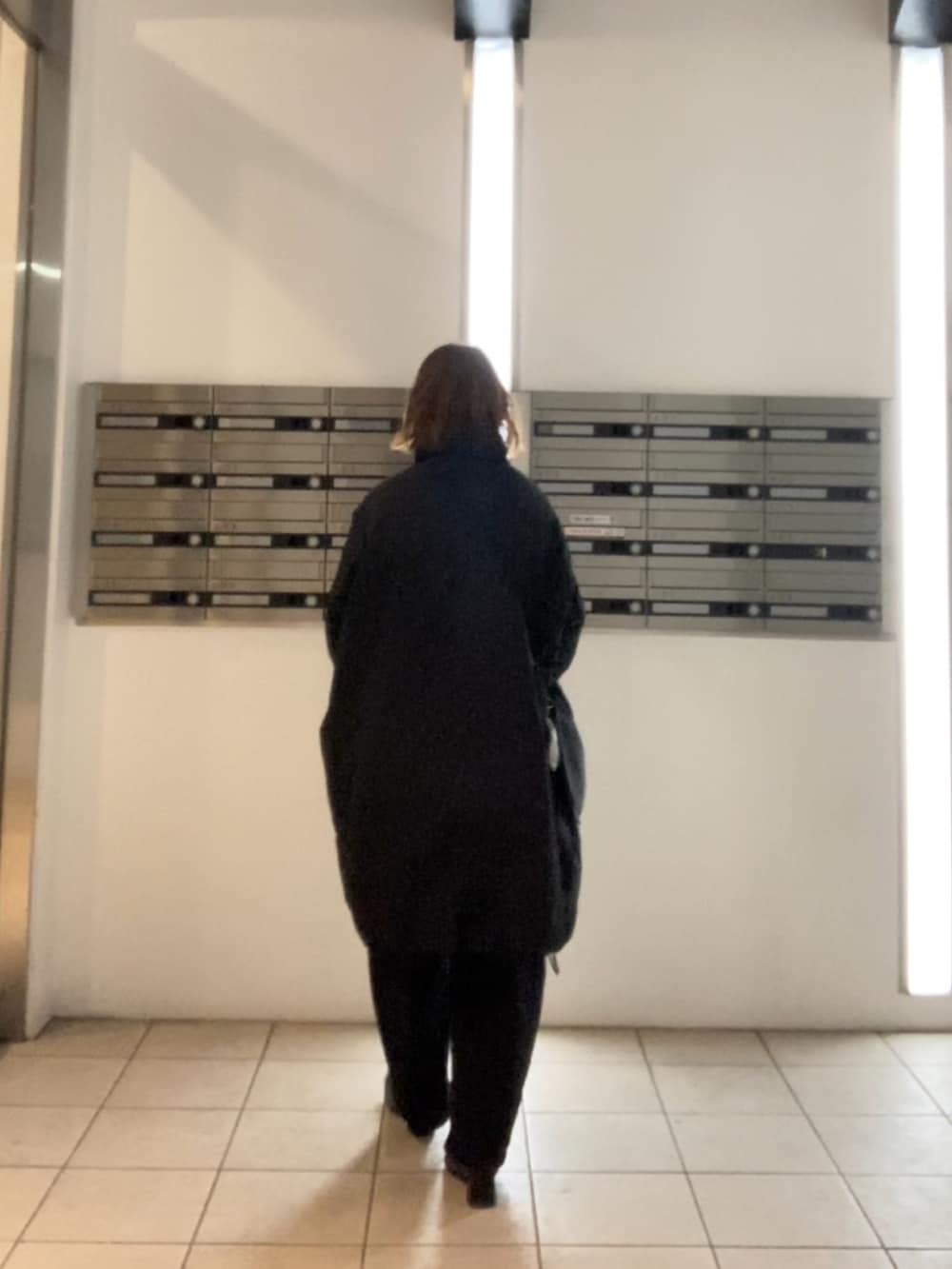 ブラック系のダウンジャケット/コート、ブラック系のブーツ、ホワイト系のデニムパンツを着用したレディースの冬コーディネートの2枚目の写真