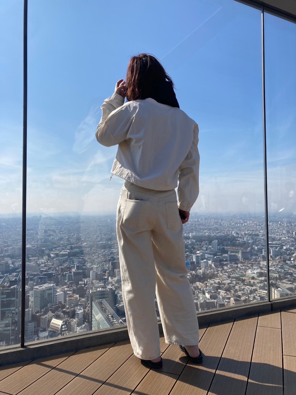 ホワイト系のデニムパンツ、ブラック系のバレエシューズ、ホワイト系のTシャツ/カットソーを着用したレディースの春コーディネートの2枚目の写真
