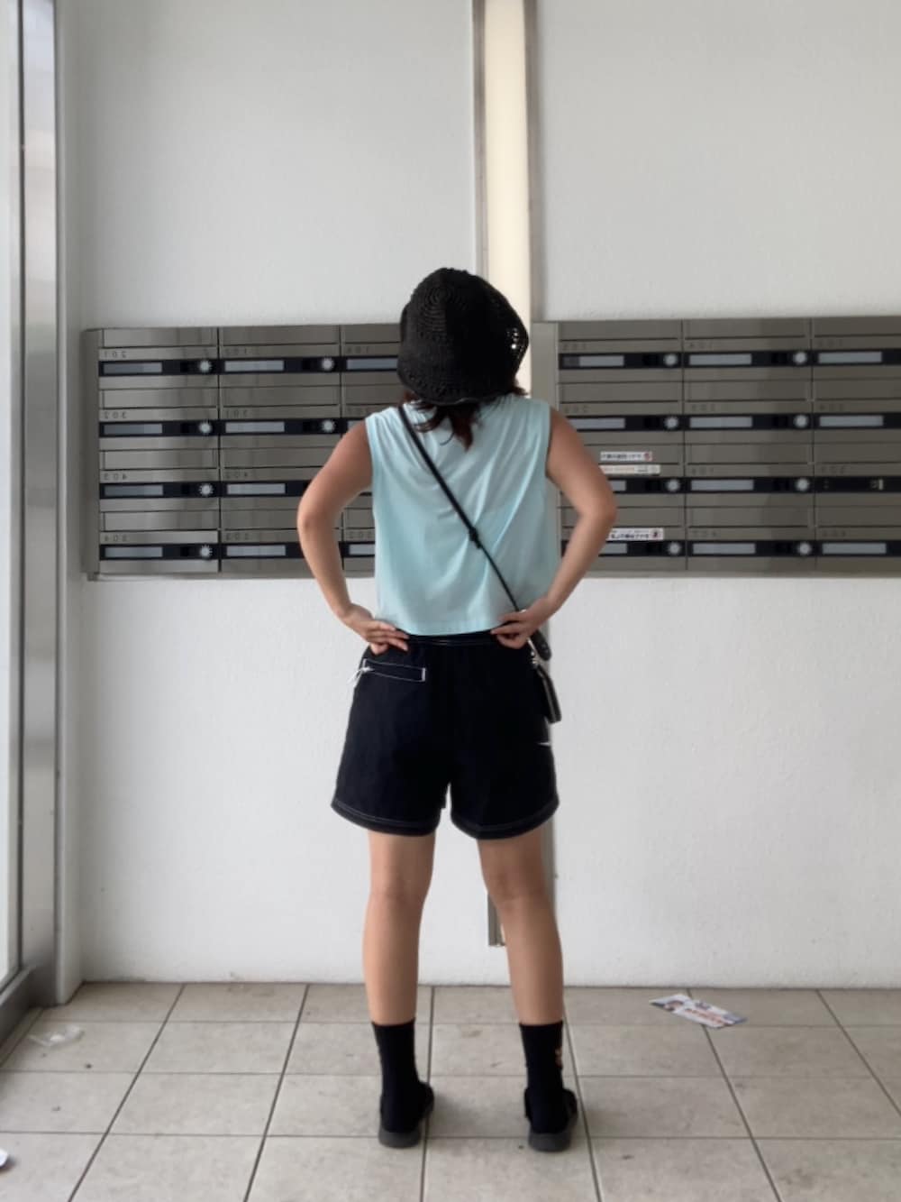 ブラック系のサンダル、ブルー系のTシャツ/カットソー、ブラック系のソックス/靴下を着用したレディースの夏コーディネートの3枚目の写真