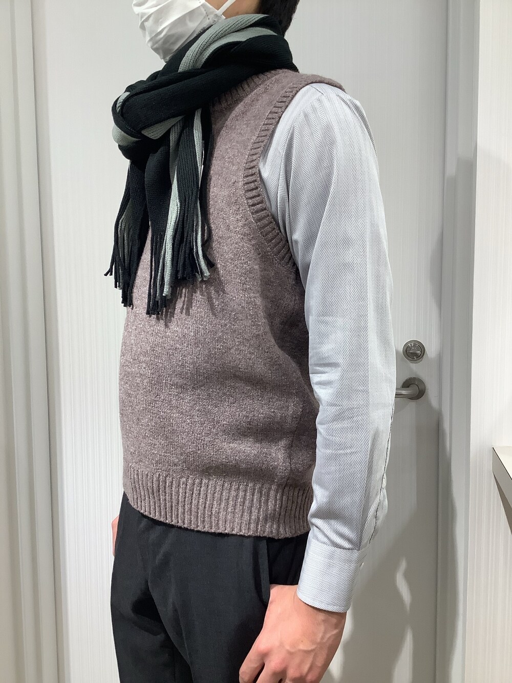 ブラウン系のベスト、グレー系のビジネスシャツ、グレー系のマフラーを着用したメンズの秋コーディネートの6枚目の写真