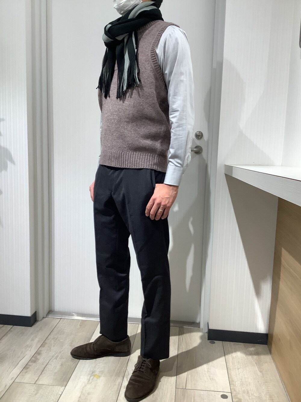 ブラウン系のベスト、グレー系のビジネスシャツ、グレー系のマフラーを着用したメンズの秋コーディネートの5枚目の写真