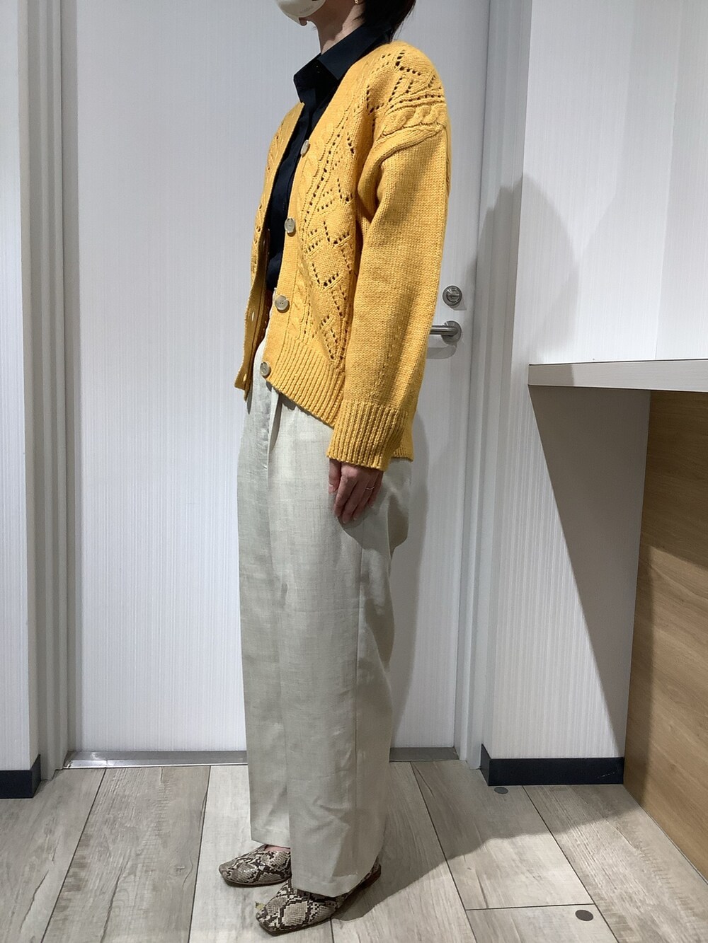 イエロー系のカーディガン/ボレロ、ブラック系のビジネスシャツを着用したレディースの秋コーディネートの5枚目の写真