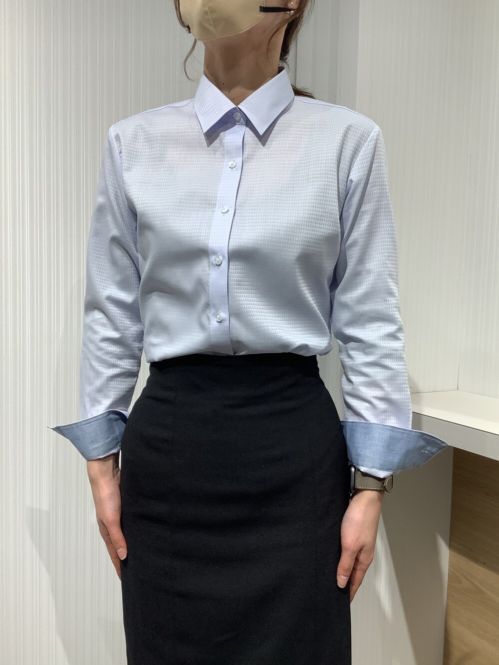 ブルー系のビジネスシャツを着用したレディースの冬コーディネートの2枚目の写真