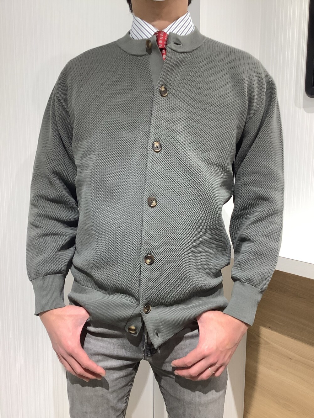 グリーン系のカーディガン/ボレロ、ブルー系のビジネスシャツ、レッド系のネクタイを着用したメンズの冬コーディネートの2枚目の写真