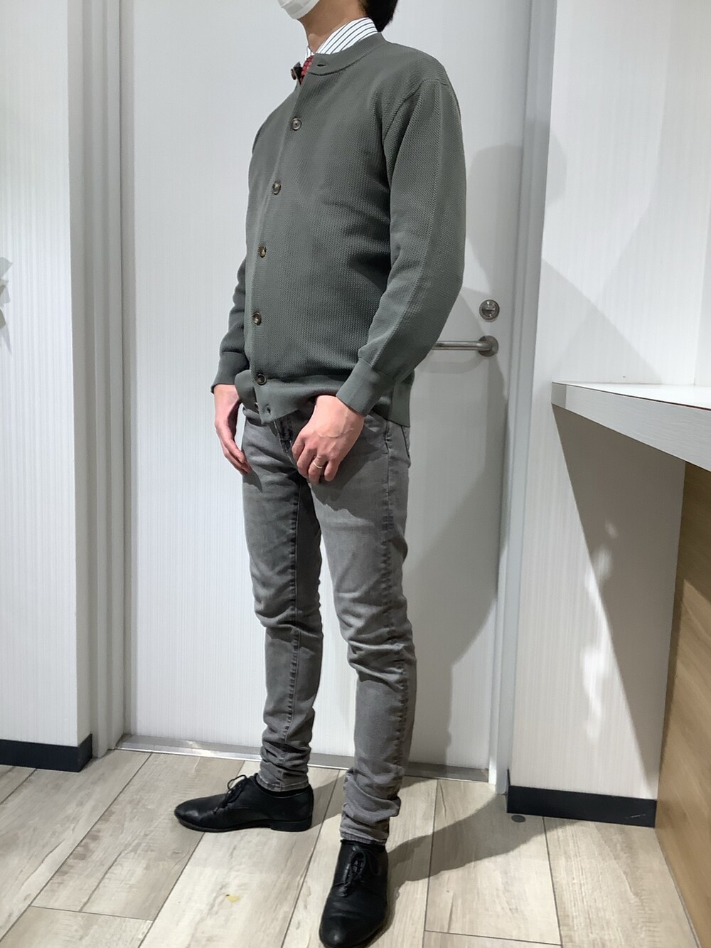 グリーン系のカーディガン/ボレロ、ブルー系のビジネスシャツ、レッド系のネクタイを着用したメンズの冬コーディネートの5枚目の写真