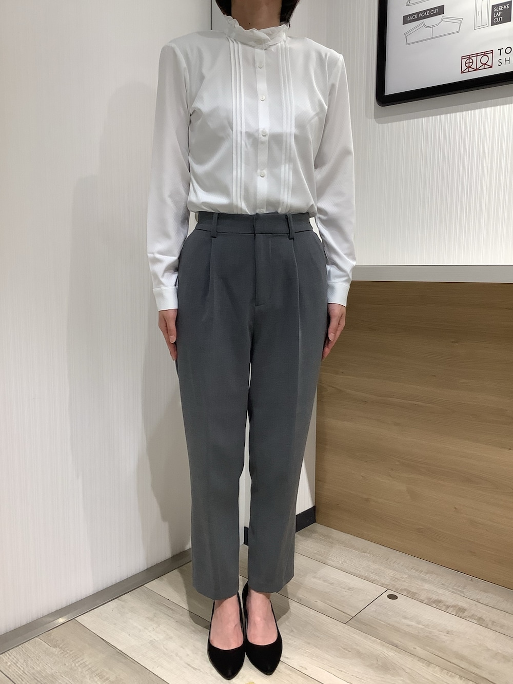 ホワイト系のビジネスシャツ、グレー系のスーツジャケット、ブラック系のパンプスを着用したレディースの夏コーディネートの6枚目の写真