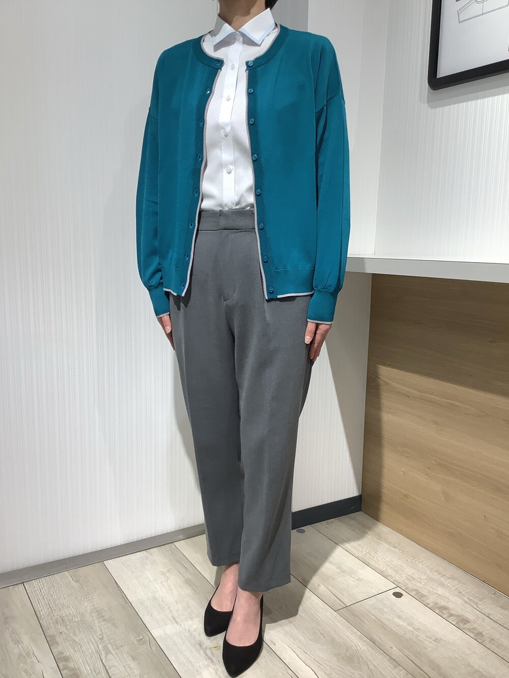 ブルー系のビジネスシャツ、グリーン系のカーディガン/ボレロを着用したレディースの春コーディネートの3枚目の写真