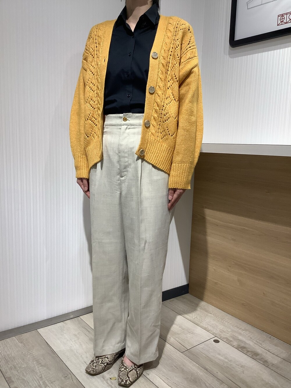 イエロー系のカーディガン/ボレロ、ブラック系のビジネスシャツを着用したレディースの秋コーディネートの3枚目の写真