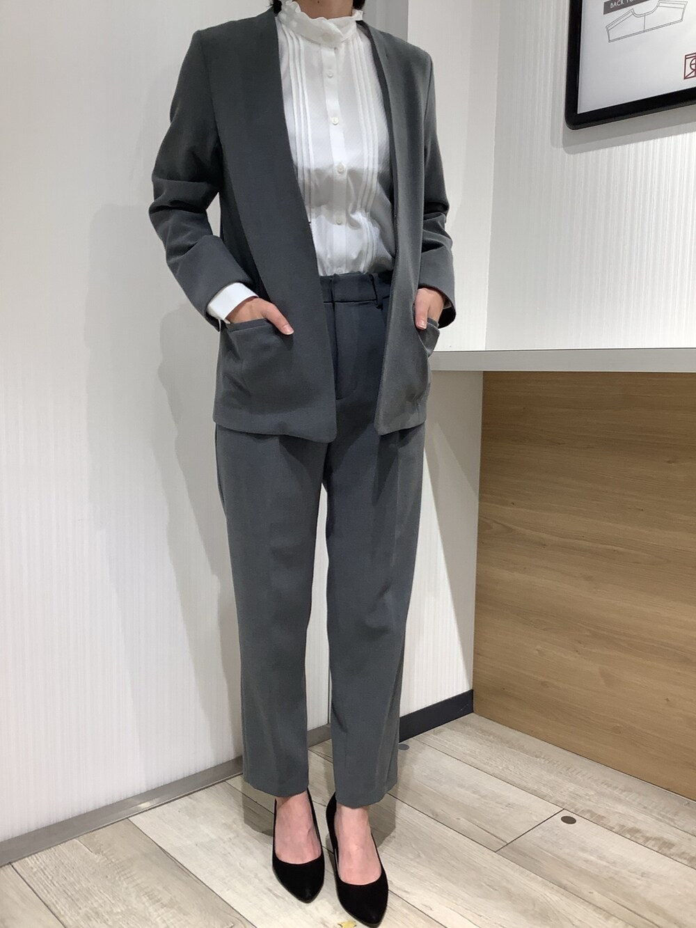 ホワイト系のビジネスシャツ、グレー系のスーツジャケット、ブラック系のパンプスを着用したレディースの夏コーディネートの3枚目の写真