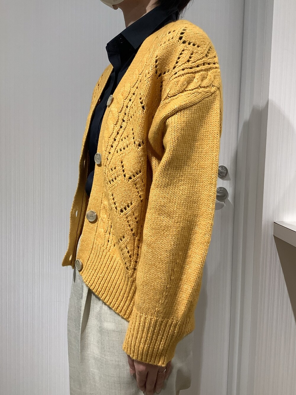 イエロー系のカーディガン/ボレロ、ブラック系のビジネスシャツを着用したレディースの秋コーディネートの6枚目の写真