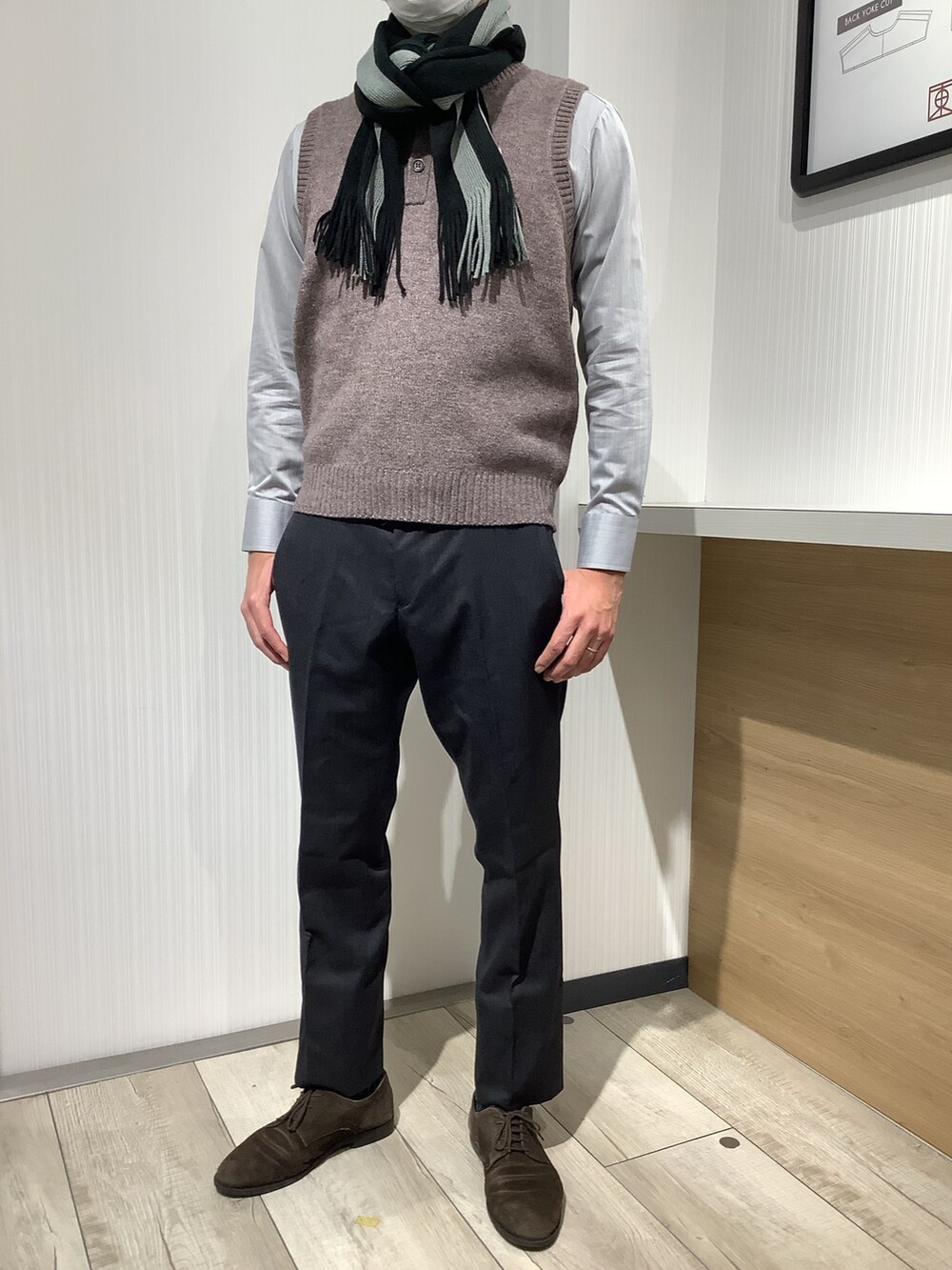 ブラウン系のベスト、グレー系のビジネスシャツ、グレー系のマフラーを着用したメンズの秋コーディネートの3枚目の写真