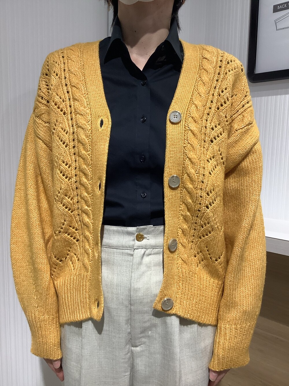 イエロー系のカーディガン/ボレロ、ブラック系のビジネスシャツを着用したレディースの秋コーディネートの2枚目の写真