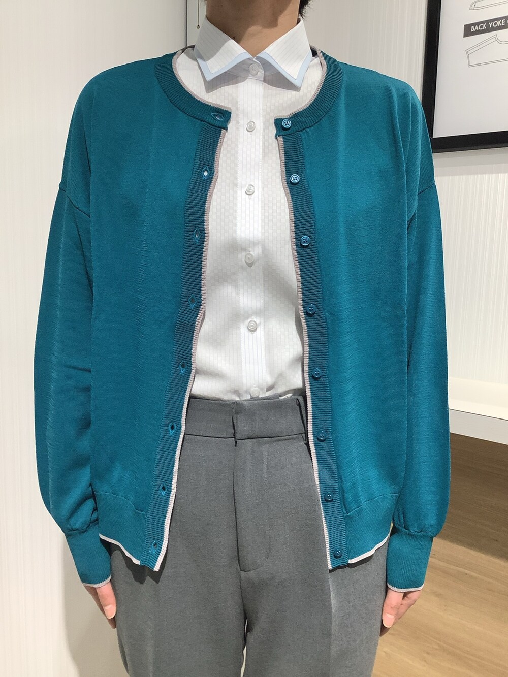 ブルー系のビジネスシャツ、グリーン系のカーディガン/ボレロを着用したレディースの春コーディネートの2枚目の写真