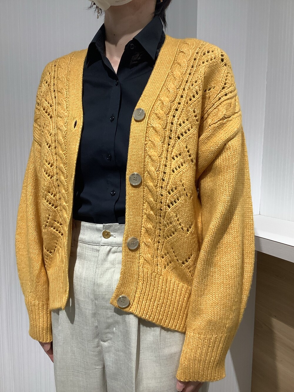 イエロー系のカーディガン/ボレロ、ブラック系のビジネスシャツを着用したレディースの秋コーディネートの4枚目の写真