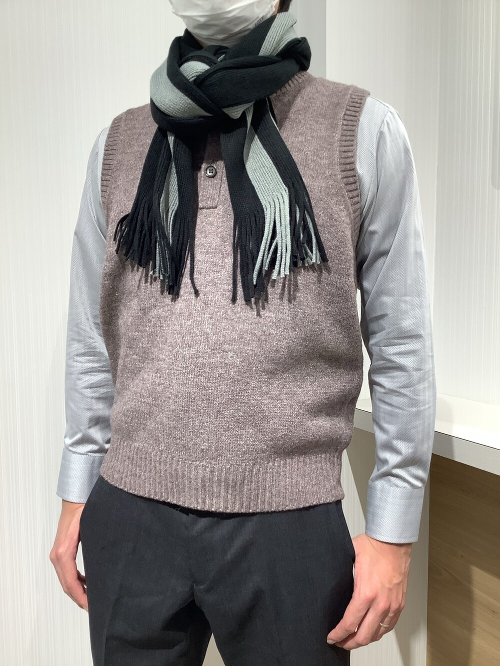 ブラウン系のベスト、グレー系のビジネスシャツ、グレー系のマフラーを着用したメンズの秋コーディネートの4枚目の写真