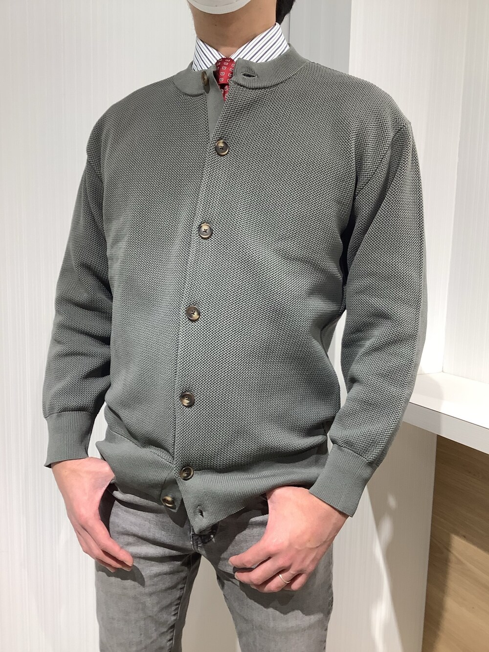 グリーン系のカーディガン/ボレロ、ブルー系のビジネスシャツ、レッド系のネクタイを着用したメンズの冬コーディネートの4枚目の写真