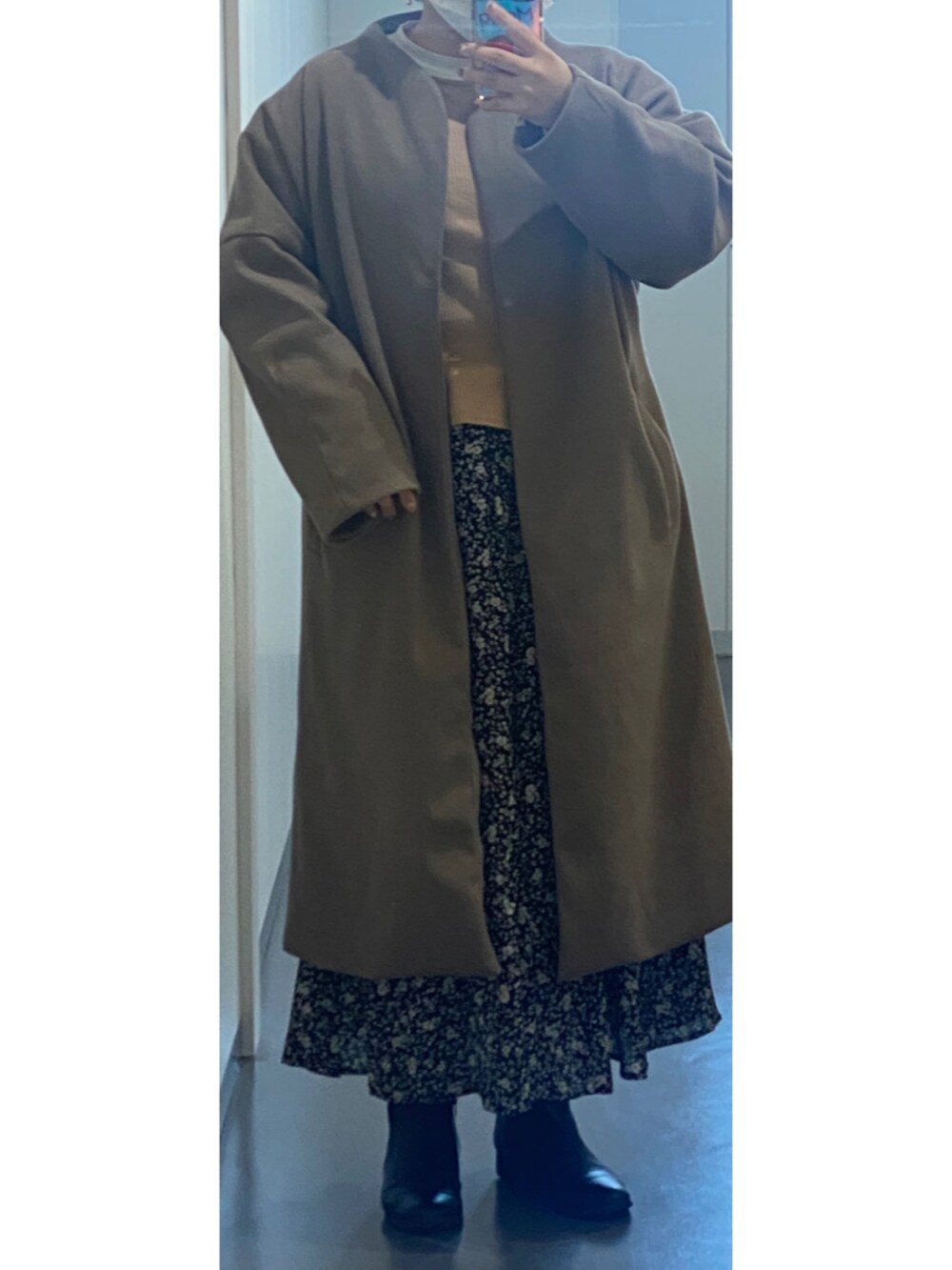 ピンク系のTシャツ/カットソー、ブラック系のスカート、グレー系のノーカラーコートを着用したレディースの冬コーディネートの2枚目の写真