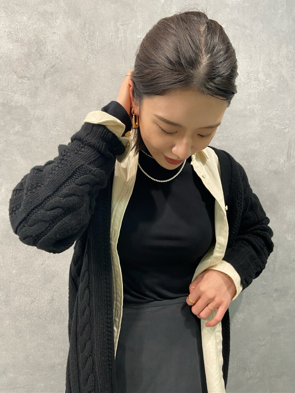 ホワイト系のシャツ/ブラウス、ブラック系のカーディガン/ボレロ、グレー系のスカートを着用したレディースの秋コーディネートの2枚目の写真