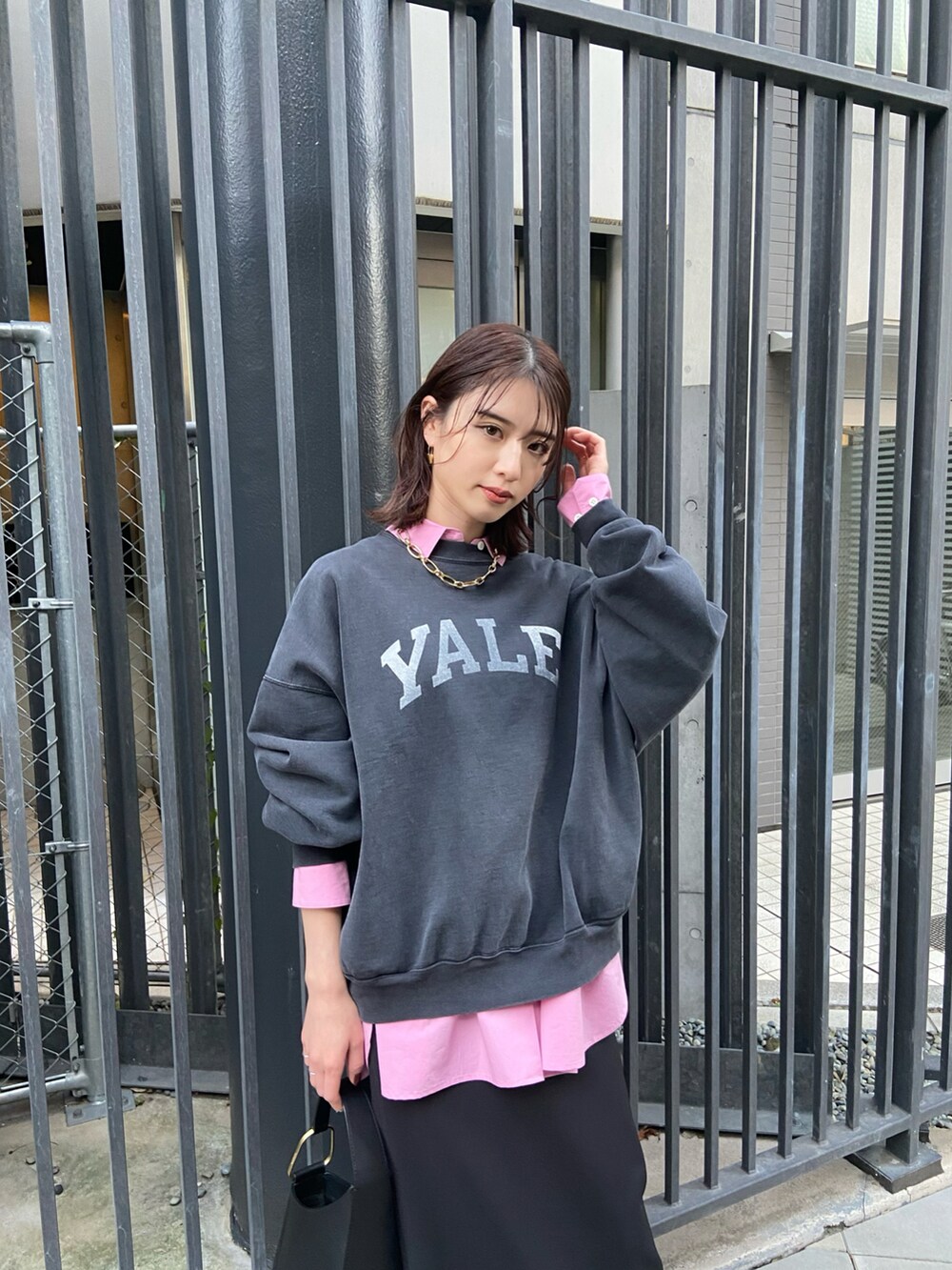 ブラック系のスウェット、ブラック系のスカート、ブラック系のブーツを着用したレディースの冬コーディネートの2枚目の写真