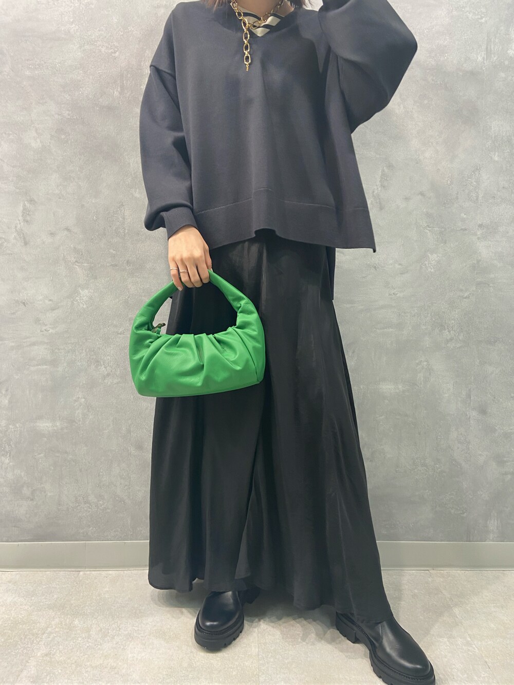 ブラック系のワンピース、グリーン系のハンドバッグ、グレー系のニット/セーターを着用したレディースの秋コーディネートの3枚目の写真