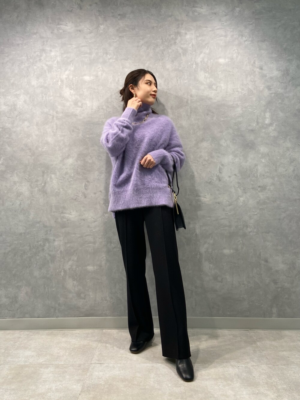 パープル系のニット/セーター、ブラック系のショルダーバッグ、ブラック系のその他パンツを着用したレディースの冬コーディネートの2枚目の写真