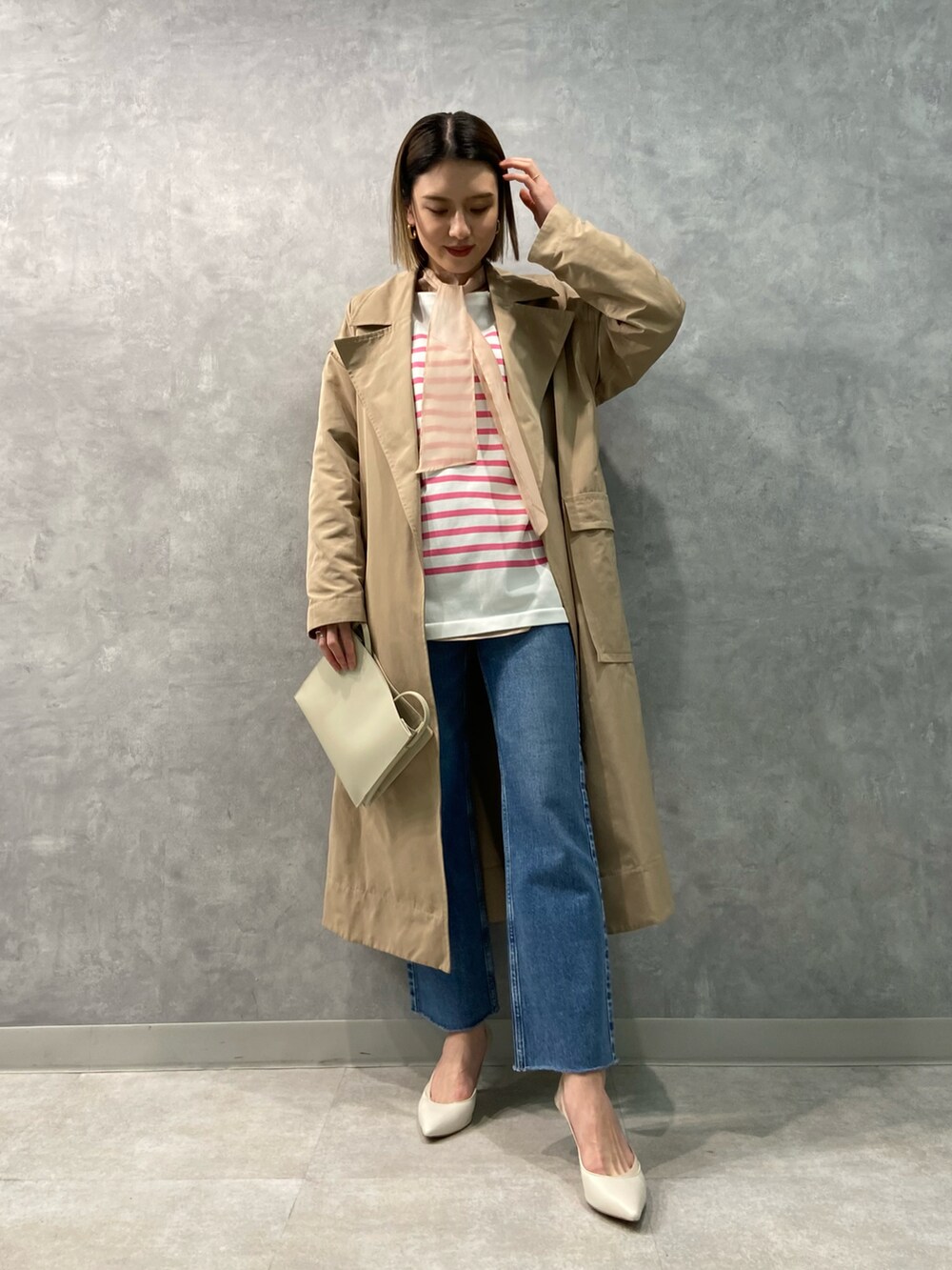 ベージュ系のジャケット/アウター、グレー系のショルダーバッグ、ブルー系のデニムパンツを着用したレディースの冬コーディネートの2枚目の写真