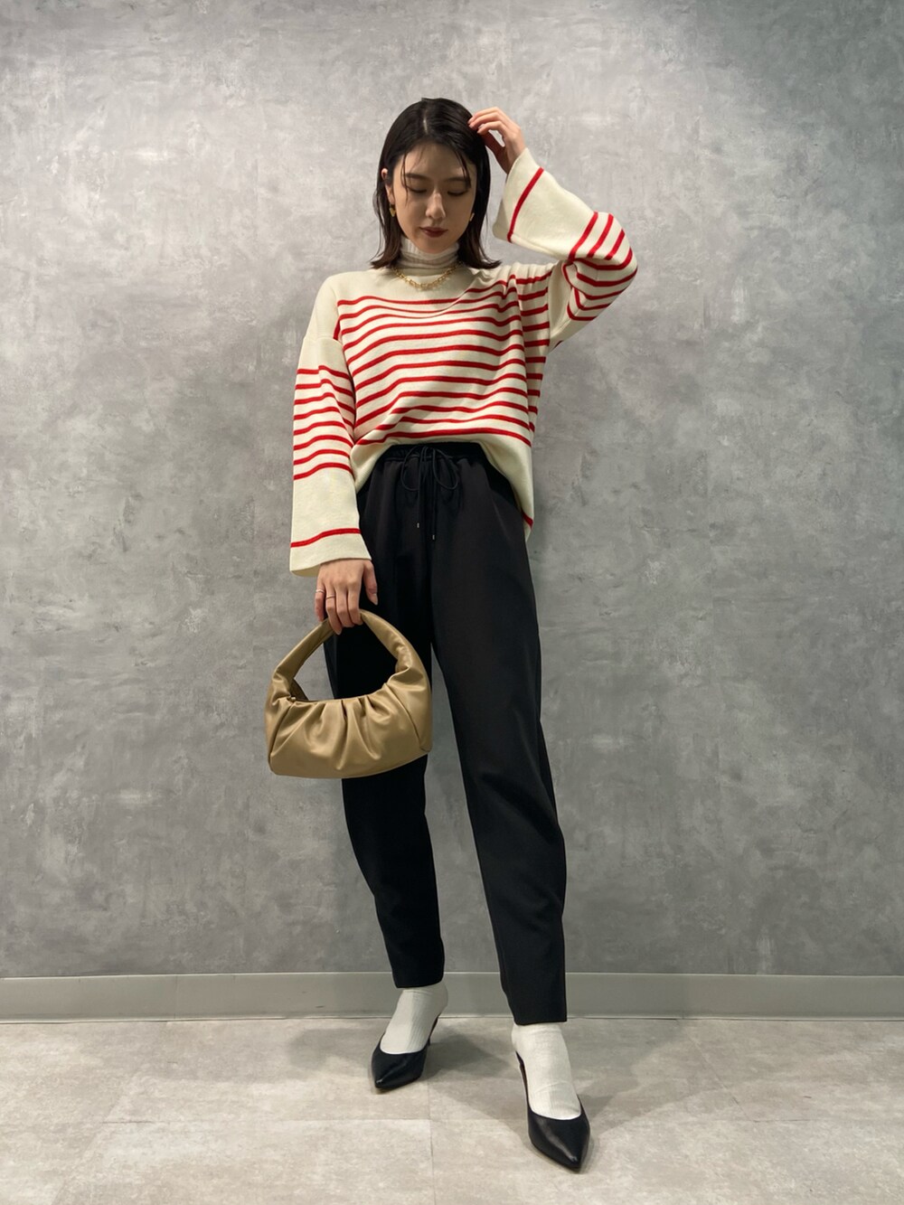 レッド系のニット/セーター、ブラック系のその他パンツ、ブラック系のパンプスを着用したレディースの冬コーディネートの2枚目の写真