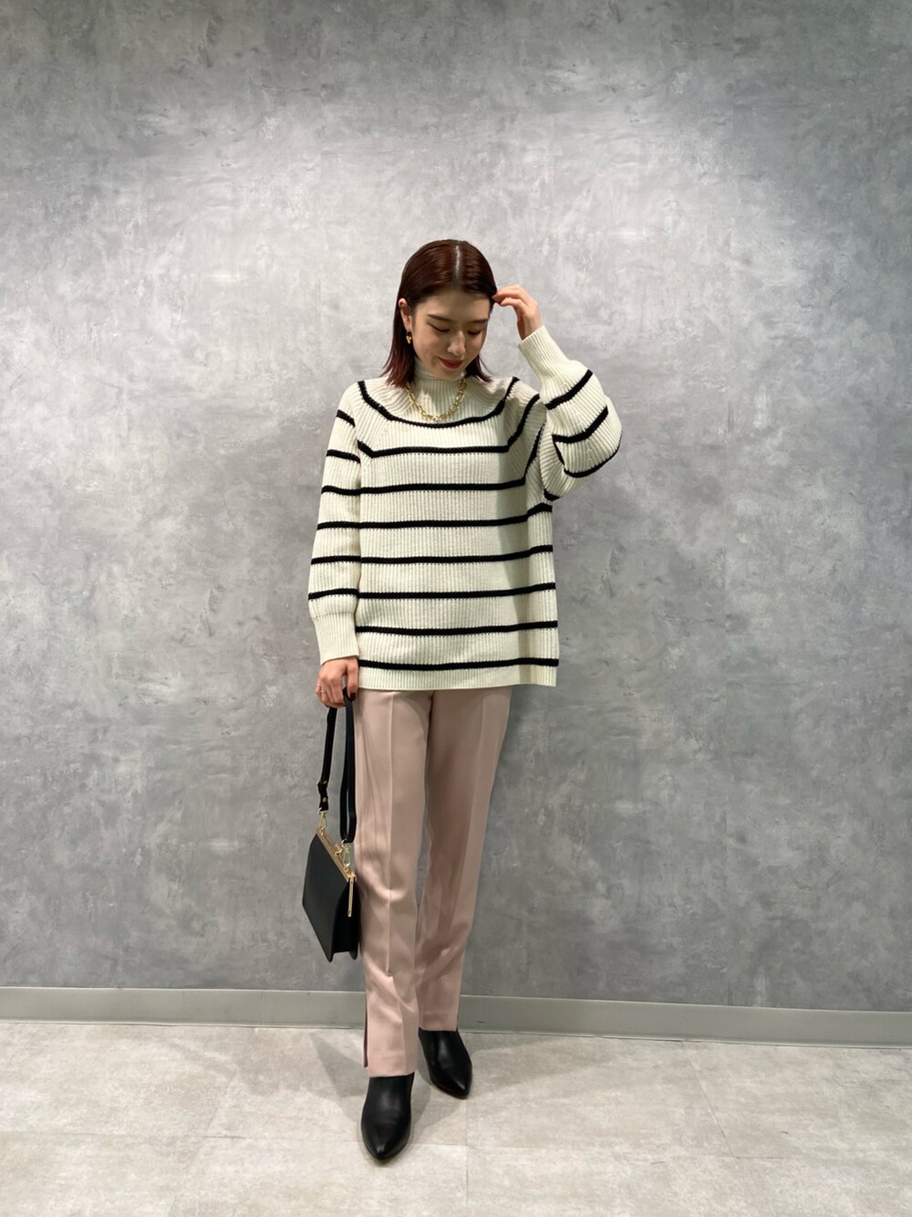 ホワイト系のニット/セーター、ピンク系のその他パンツ、ブラック系のショルダーバッグを着用したレディースの冬コーディネートの2枚目の写真