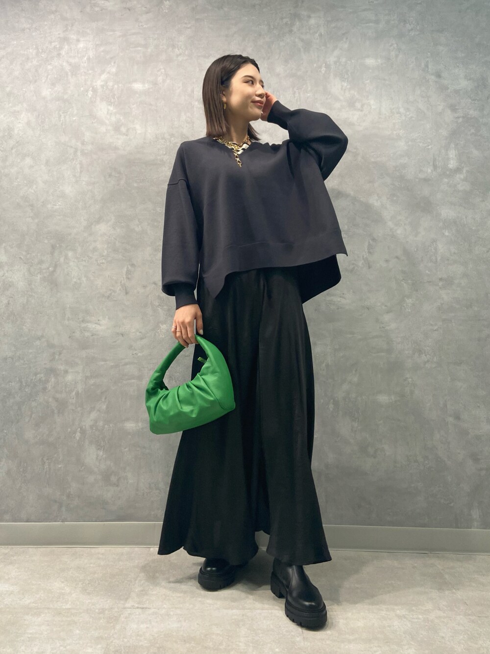 ブラック系のワンピース、グリーン系のハンドバッグ、グレー系のニット/セーターを着用したレディースの秋コーディネートの2枚目の写真