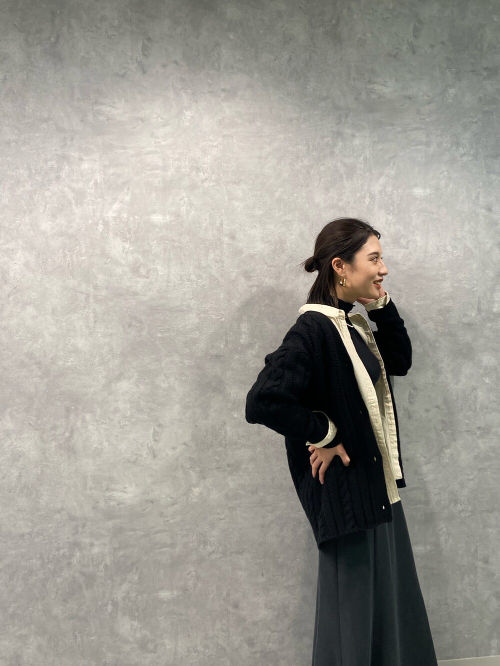 ホワイト系のシャツ/ブラウス、ブラック系のカーディガン/ボレロ、グレー系のスカートを着用したレディースの秋コーディネートの3枚目の写真