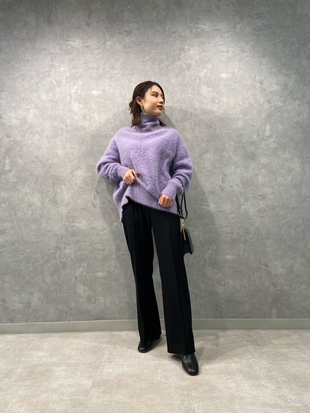 パープル系のニット/セーター、ブラック系のショルダーバッグ、ブラック系のその他パンツを着用したレディースの冬コーディネートの3枚目の写真