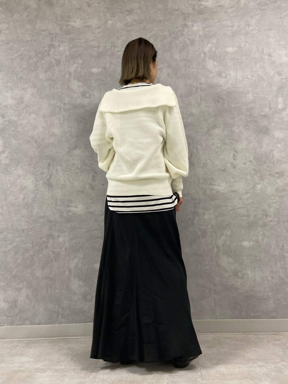 ブラック系のワンピース、ブラック系のショルダーバッグ、ホワイト系のニット/セーターを着用したレディースの冬コーディネートの3枚目の写真