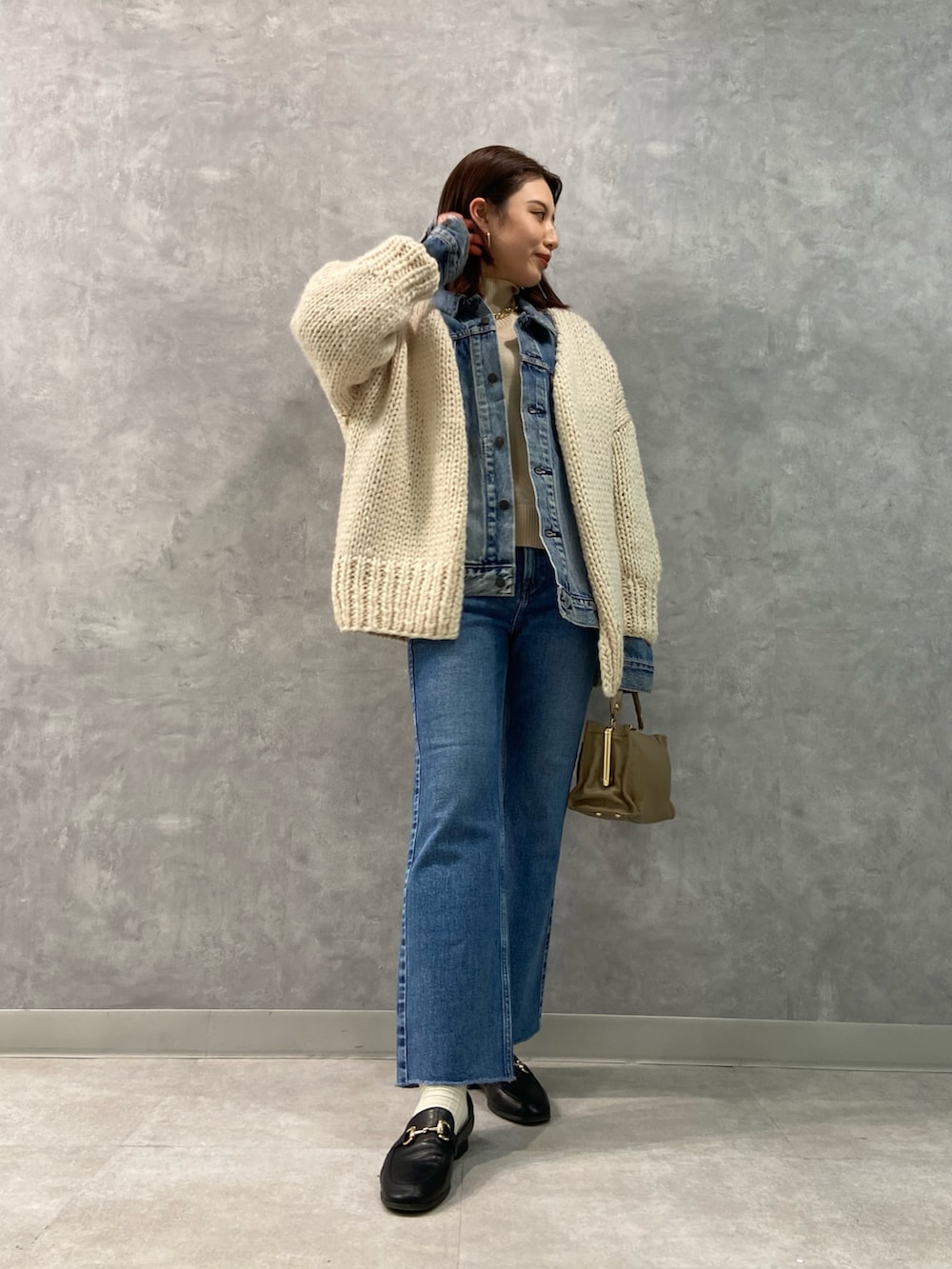 ブルー系のデニムパンツ、ホワイト系のニット/セーター、ブルー系のデニムジャケットを着用したレディースの冬コーディネートの2枚目の写真