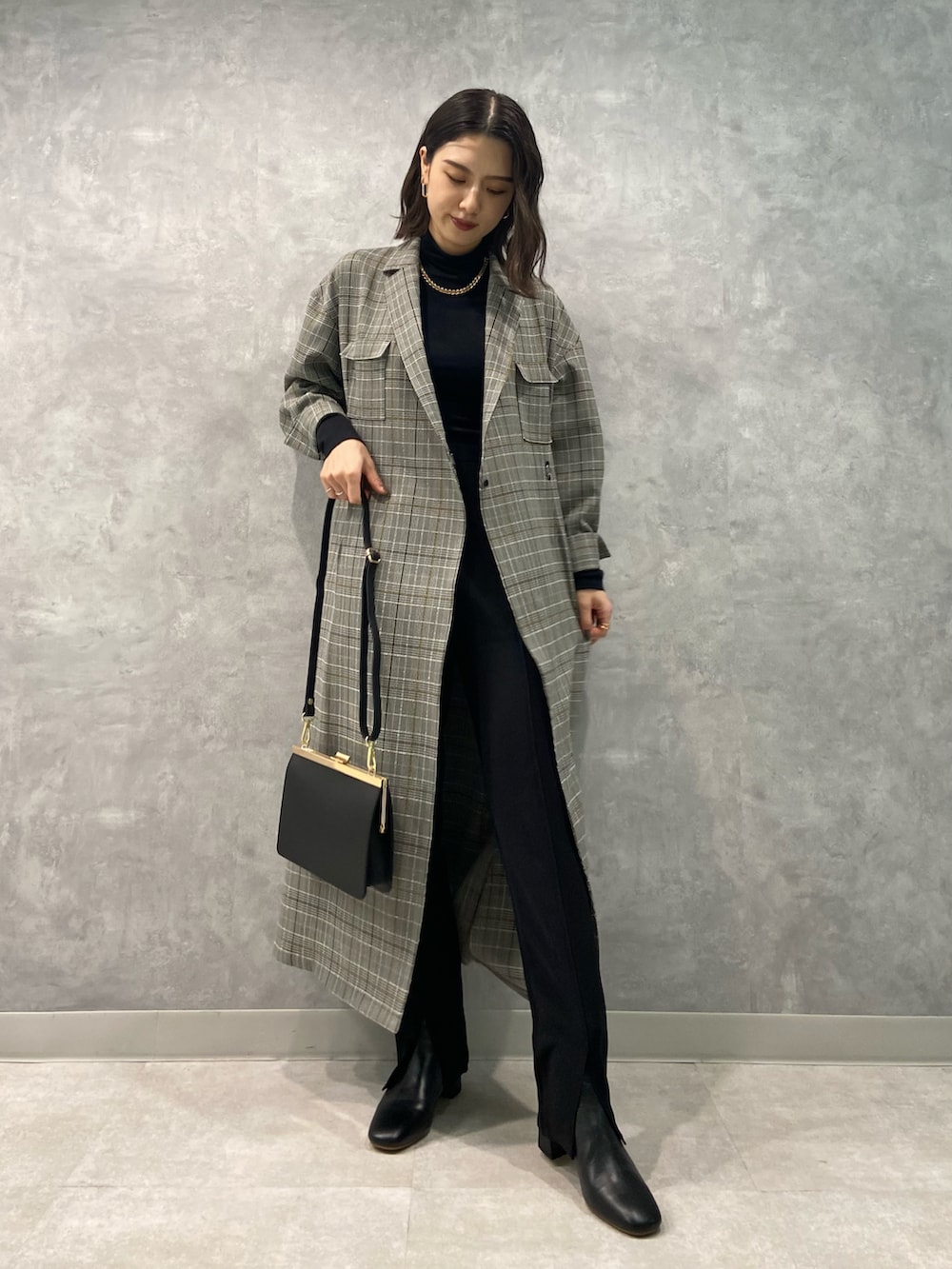 ブラック系のショルダーバッグ、ブラック系のその他パンツ、ブラック系のブーツを着用したレディースの秋コーディネートの2枚目の写真