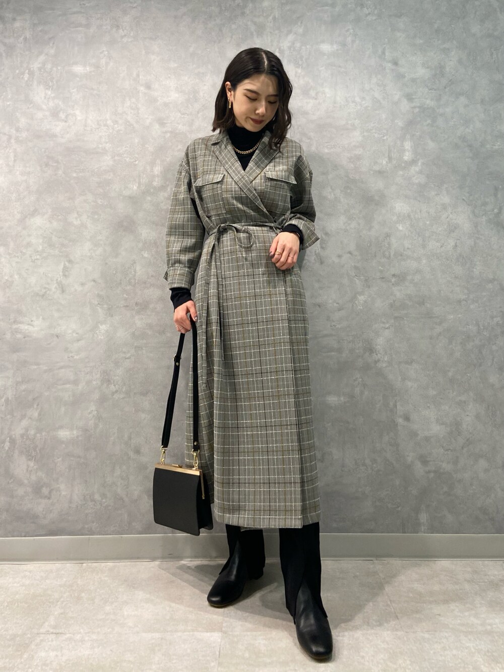 ブラック系のワンピース、ブラック系のブーツ、ブラック系のショルダーバッグを着用したレディースの秋コーディネートの2枚目の写真